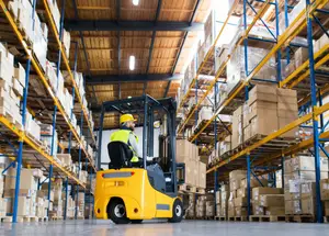 Forklift operator moving goods in a warehouse
